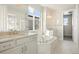 Bright bathroom featuring double sinks, soaking tub, shower, and tile floors at 10659 Montecito Dr, Lone Tree, CO 80124