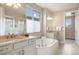 Bright bathroom with dual vanities, soaking tub, and natural light from a large window at 10659 Montecito Dr, Lone Tree, CO 80124