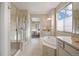 Bright bathroom with shower, soaking tub, and view into a bedroom at 10659 Montecito Dr, Lone Tree, CO 80124
