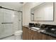 Modern bathroom with a black granite countertop, glass shower, and stylish fixtures at 10659 Montecito Dr, Lone Tree, CO 80124