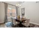Modern dining room with a chandelier, large window, and view into the kitchen at 10659 Montecito Dr, Lone Tree, CO 80124