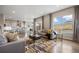 Bright living room with hardwood floors, stylish rug, and an open-concept design into the kitchen at 10659 Montecito Dr, Lone Tree, CO 80124