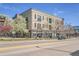 Three-story commercial building with balconies and decorative accents, surrounded by blossoming trees at 2501 15Th St # 3F, Denver, CO 80211