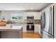 Well-lit kitchen with stainless steel appliances, granite countertops, and an island, perfect for meal prep and entertaining at 21961 E Crestline Pl, Aurora, CO 80015