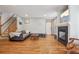 Open-concept living room with hardwood floors, fireplace, and staircase at 21961 E Crestline Pl, Aurora, CO 80015