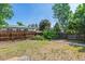 Fenced backyard with mature trees is ready for landscaping and outdoor enjoyment at 3253 S Kalispell St, Aurora, CO 80013