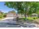 Charming brick and siding home with an attached garage, lush lawn, and a large shade tree in the front yard at 3253 S Kalispell St, Aurora, CO 80013