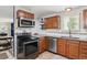 Well-equipped kitchen with stainless steel appliances, wood cabinets, granite countertops, and tile backsplash at 3253 S Kalispell St, Aurora, CO 80013