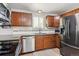 Modern kitchen featuring stainless steel appliances, wood cabinets, granite countertops, and stylish tile backsplash at 3253 S Kalispell St, Aurora, CO 80013