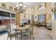 Open-concept dining area with elegant table and chairs, adjacent to living room with stone fireplace and backyard access at 10041 Dillon Cir, Commerce City, CO 80022