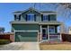 Inviting two-story home featuring an attached two-car garage, well-manicured lawn, and classic architectural details at 10041 Dillon Cir, Commerce City, CO 80022