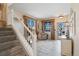 Bright foyer featuring tile flooring, neutral colors, window views, lots of light, and stairs to the upper level at 10041 Dillon Cir, Commerce City, CO 80022