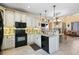 Open-concept kitchen boasts white cabinets, black appliances, granite countertops, and adjacent living area at 10041 Dillon Cir, Commerce City, CO 80022