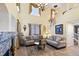 Spacious living room showcasing a fireplace, tall ceilings, big windows, comfortable sofas, and neutral decor at 10041 Dillon Cir, Commerce City, CO 80022