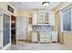 Kitchen features a pantry with frosted glass doors, ample shelving, and natural light at 10041 Dillon Cir, Commerce City, CO 80022