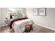 Cozy bedroom featuring a comfortable bed, wood flooring, and natural light from the window at 1011 Yeager Dr, Longmont, CO 80501