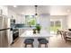 Modern kitchen featuring white cabinets, stainless steel appliances, an island with seating, and backyard views at 1011 Yeager Dr, Longmont, CO 80501