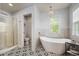Modern bathroom featuring soaking tub, glass shower and decorative tile flooring at 8728 E 25Th Dr, Denver, CO 80238