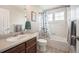 Bright bathroom featuring vanity, tub with shower and leaf-patterned shower curtain at 8728 E 25Th Dr, Denver, CO 80238
