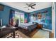 Stylish bedroom with desk, electric guitar, star-themed curtains, and blue walls at 8728 E 25Th Dr, Denver, CO 80238