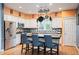 Stylish kitchen featuring white cabinets, stainless steel appliances, and a spacious center island with seating at 8728 E 25Th Dr, Denver, CO 80238