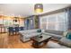 Spacious living room with hardwood floors, comfortable sectional sofa, and stylish decor, open to kitchen at 8728 E 25Th Dr, Denver, CO 80238