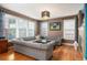 Inviting living room with hardwood floors, large windows, and a comfortable sectional sofa at 8728 E 25Th Dr, Denver, CO 80238