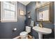 Stylish powder room with vessel sink, updated fixtures, and dark blue walls at 8728 E 25Th Dr, Denver, CO 80238