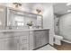 Well-lit bathroom featuring double vanity, marble countertop, and tiled shower at 1551 Larimer St # 2704, Denver, CO 80202