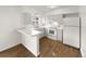 Kitchen with white cabinets, laminate countertops, and a breakfast bar at 4689 S Lowell Blvd, Denver, CO 80236