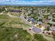 Expansive aerial view of a community featuring single-Gathering homes with lush green surroundings and mountain views at 22227 E Hinsdale Ave, Aurora, CO 80016