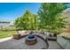 Spacious back patio with outdoor seating encircling a stone fire pit at 22227 E Hinsdale Ave, Aurora, CO 80016