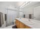 Bathroom featuring double sinks, a large mirror with lighting, and a shower with a curtain at 22227 E Hinsdale Ave, Aurora, CO 80016