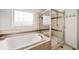 Close up of the bath and glass shower with a built in seat in the main bathroom at 22227 E Hinsdale Ave, Aurora, CO 80016