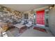 Inviting front porch with a red door, stone accents, comfortable seating, and a welcoming rug at 22227 E Hinsdale Ave, Aurora, CO 80016