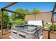 Outdoor hot tub with wood pergola, surrounded by privacy shrubs in landscaped backyard at 22227 E Hinsdale Ave, Aurora, CO 80016