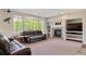 Comfortable living room with a cozy fireplace, built-in shelving, and large windows with scenic view at 22227 E Hinsdale Ave, Aurora, CO 80016