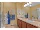 Bright bathroom with double sinks, warm neutral tones, and enclosed shower at 7828 W 54Th Ave, Arvada, CO 80002