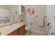 Bathroom featuring a stylish vanity, toilet, shower with floral curtain, and decorative wall art at 7828 W 54Th Ave, Arvada, CO 80002