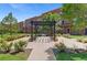 Inviting community area with a pergola, benches, manicured landscaping, and building in the background at 7828 W 54Th Ave, Arvada, CO 80002