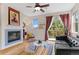 Bright living room with fireplace, ceiling fan, and balcony access with views of lush greenery at 7828 W 54Th Ave, Arvada, CO 80002