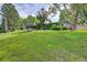 Expansive backyard with lush green grass, mature trees, and established landscaping at 8300 W 67Th Ave, Arvada, CO 80004