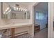 Bathroom features a long vanity with bright lighting, a mirrored wall and access to an additional room at 8300 W 67Th Ave, Arvada, CO 80004