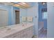 Bright bathroom with double sinks, a large mirror, and a separate area for the bathtub and toilet at 8300 W 67Th Ave, Arvada, CO 80004