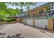View of home featuring multiple garage spaces, yellow-painted walls, and a spacious driveway at 8300 W 67Th Ave, Arvada, CO 80004