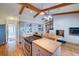 Bright kitchen and dining area with hardwood floors, wood beams, an island, and gas range at 8300 W 67Th Ave, Arvada, CO 80004