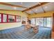 Open living room space featuring wood paneling, vaulted ceilings, and a sunroom with a patio at 8300 W 67Th Ave, Arvada, CO 80004