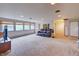Bright living room featuring large windows and neutral carpeting throughout the open space at 8300 W 67Th Ave, Arvada, CO 80004