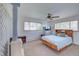 A spacious main bedroom features a ceiling fan, a faux fireplace and large windows allowing plenty of natural light at 8300 W 67Th Ave, Arvada, CO 80004