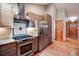 View of the kitchen with stainless steel appliances, wooden cabinets, hardwood floors, and hood vent at 3428 W County Road 4, Berthoud, CO 80513